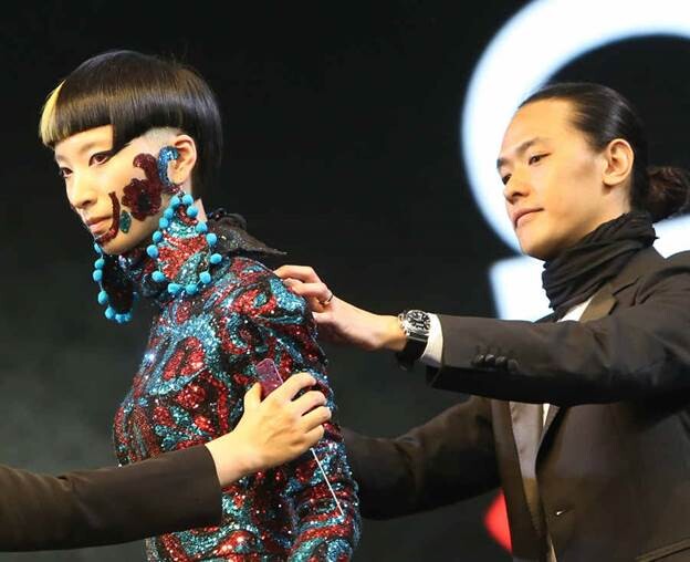 Un coiffeur travaille sur la tenue d'un mannequin lors de la 9e édition du Festival Asiatique de Coiffure, mercredi à Shanghai. Le festival, qui a débuté mercredi et se termine vendredi, propose une série d'événements, comme un concours de coiffure et des sessions de formation. [Photo Gao Erqiang / Asianewsphoto]