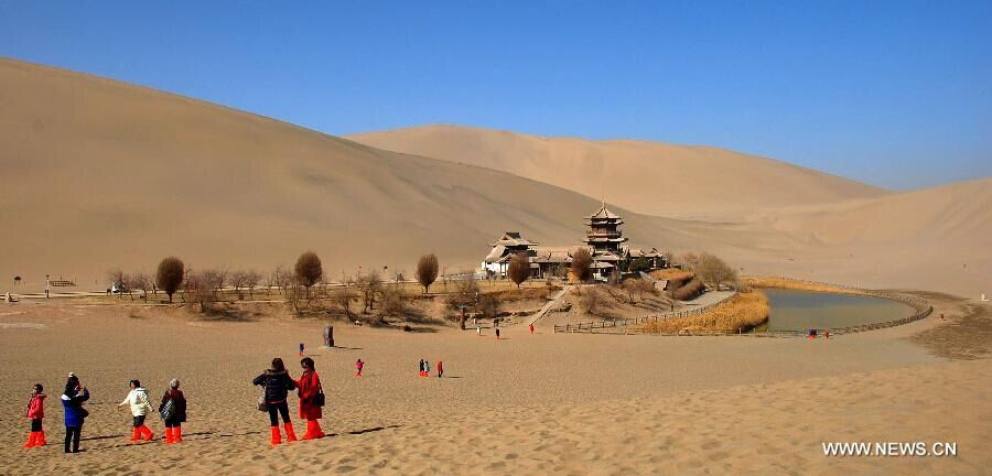 Des touristes visitent le site de la Source du Croissant de Lune à dos de chameau à Dunhuang, dans la Province du Gansu (Nord-ouest de la Chine). Avec le printemps, une certaine douceur revient, attirant les touristes. [Photo/Xinhua]