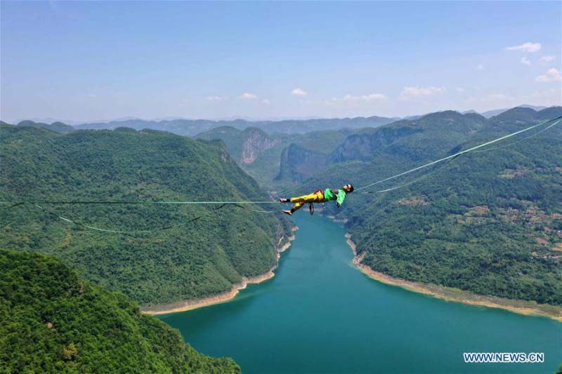 Homme fait de l'équilibre sur un fil dans une base de sports de plein air au Hubei