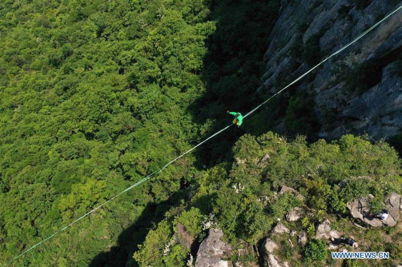 Homme fait de l'équilibre sur un fil dans une base de sports de plein air au Hubei