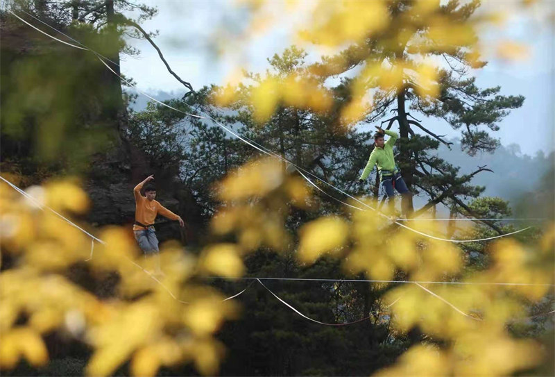 Les concurrents de slackline s'affrontent à 1 000 m d'altitude, au sommet des pics des forêts du site de Wulingyuan, dans le Hunan