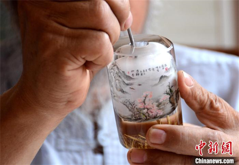 Hebei: un ma?tre de la peinture intérieure de tabatière féru d'art exerce depuis plus de 40 ans dans un village