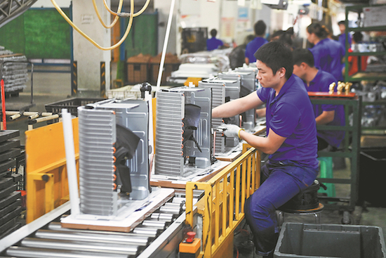 Des employés travaillent sur une cha?ne de montage de climatiseurs à Cixi dans la province du Zhejiang (est de la Chine). (Photo/Xinhua)