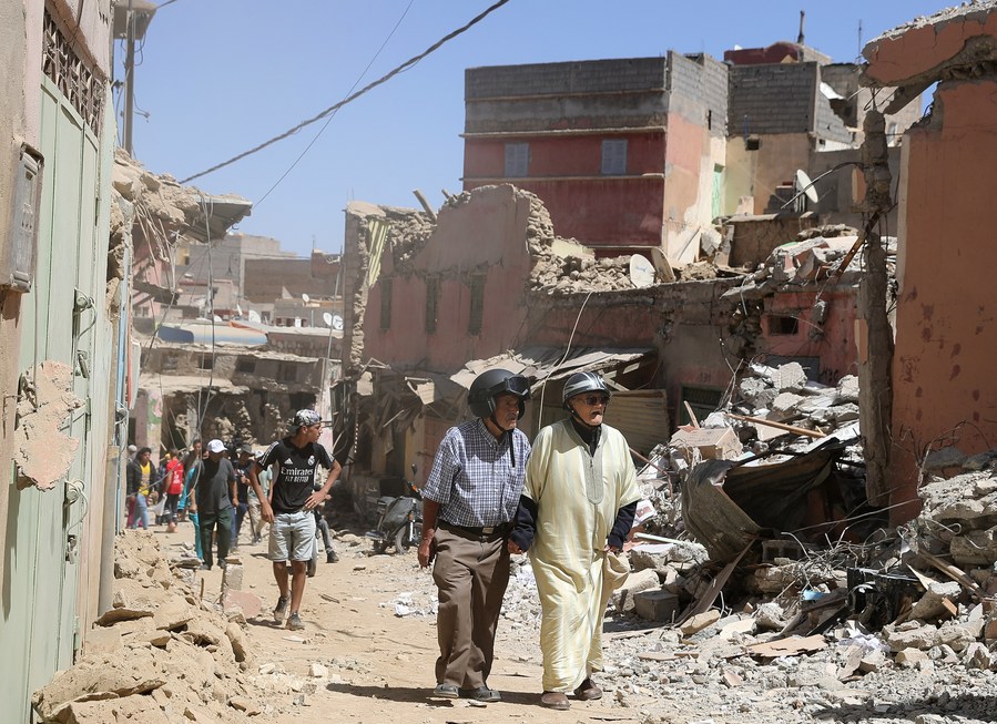 Des habitants passent devant des batiments endommagés le 10 septembre 2023 dans la petite ville d'Amizmiz, près de l'épicentre du séisme meurtrier qui a frappé le Maroc. (Xinhua/Wang Dongzhen)