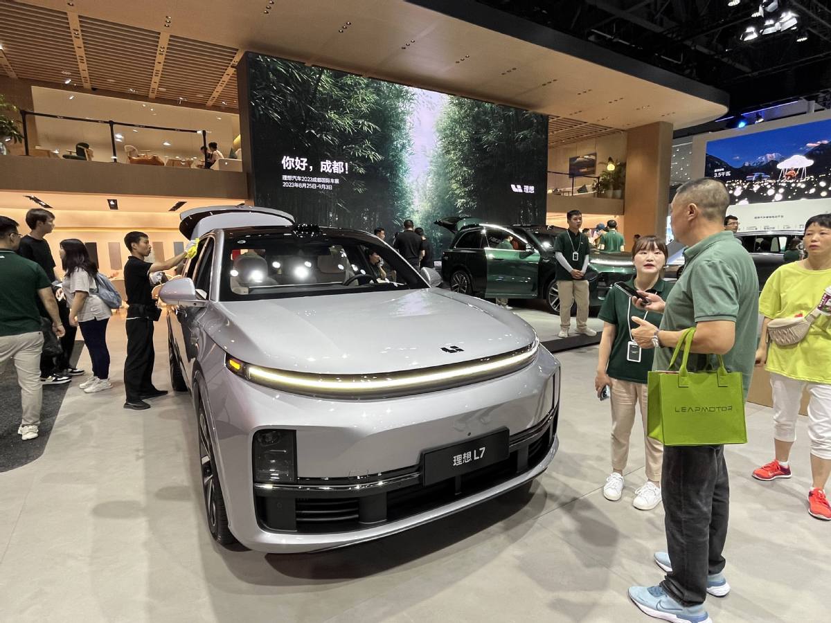 Une vendeuse présente le SUV L7 de Li Auto à un visiteur au Salon de Chengdu 2023 en ao?t. (Cao Yingying / China Daily)