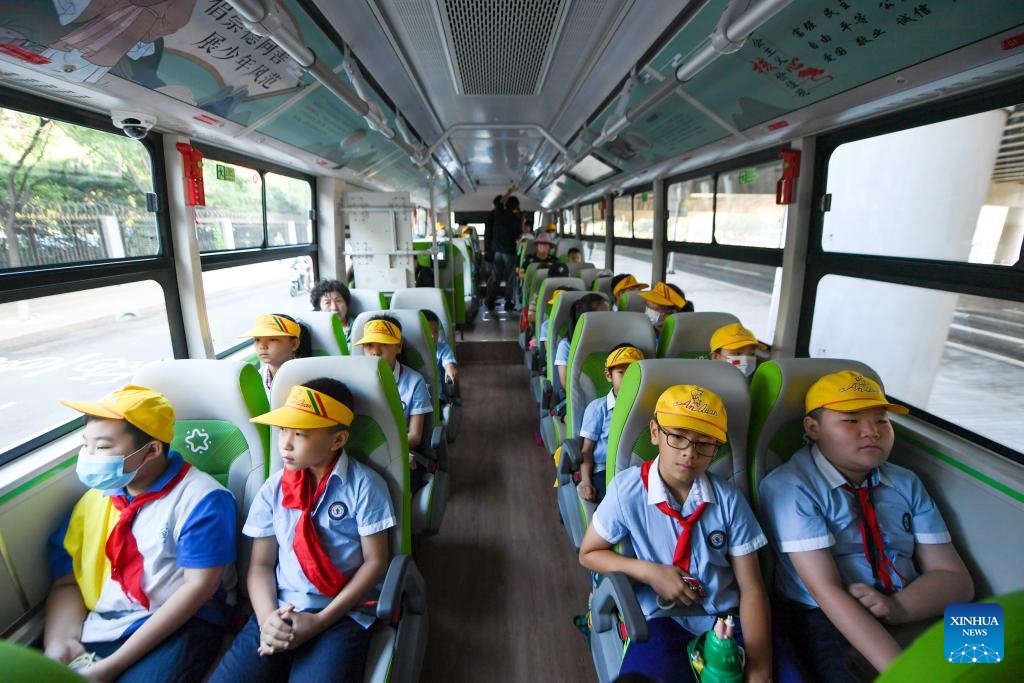 Des élèves d'une école primaire du district de Fengtai à Beijing descendent d'un bus scolaire con?u pour leur école. (Ju Huanzong / Xinhua)