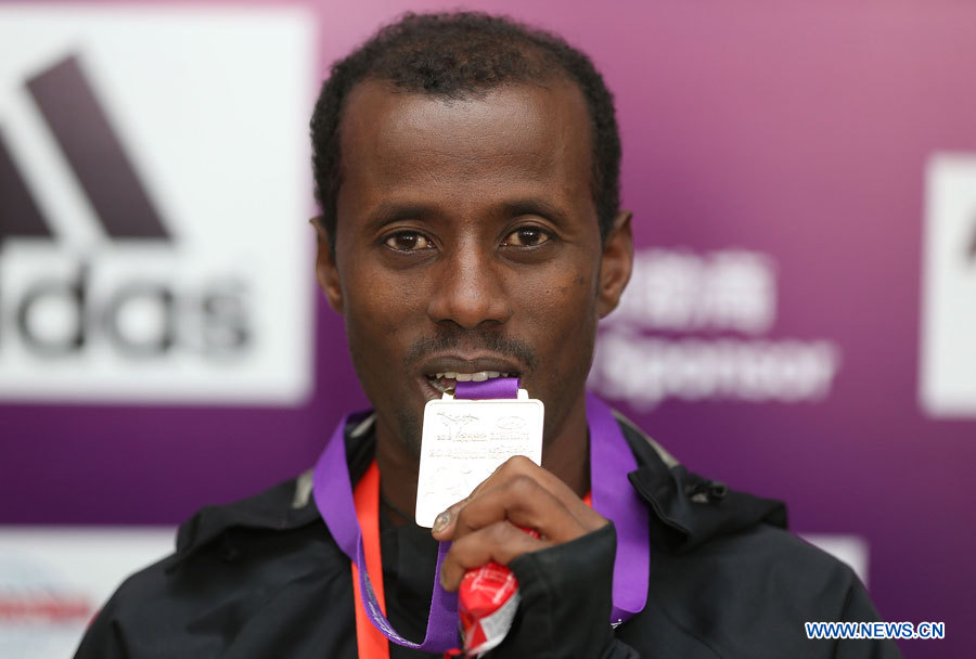 L'Ethiopien Tariku Jufar Robi montre sa médaille d'or lors de la cérémonie de remise des prix du Marathon international de Beijing, le 25 novembre 2012. Tariku Jufar Robi a remporté la médaille d'or du marathon hommes en 2 heures, 9 minutes et 39 secondes. (Photo : Guo Yong)