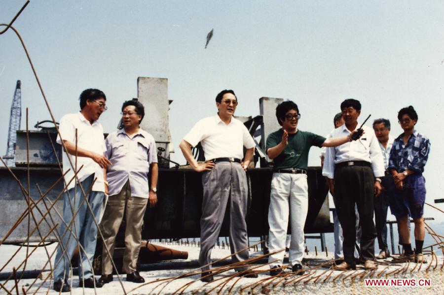 Photo d'archive prise en 1994 montrant Yu Zhengsheng (troisième à gauche) lors de son inspection sur un chantier de construction d'une autoroute enjambant la mer à Qingdao, ville c?tière de la province orientale du Shandong.