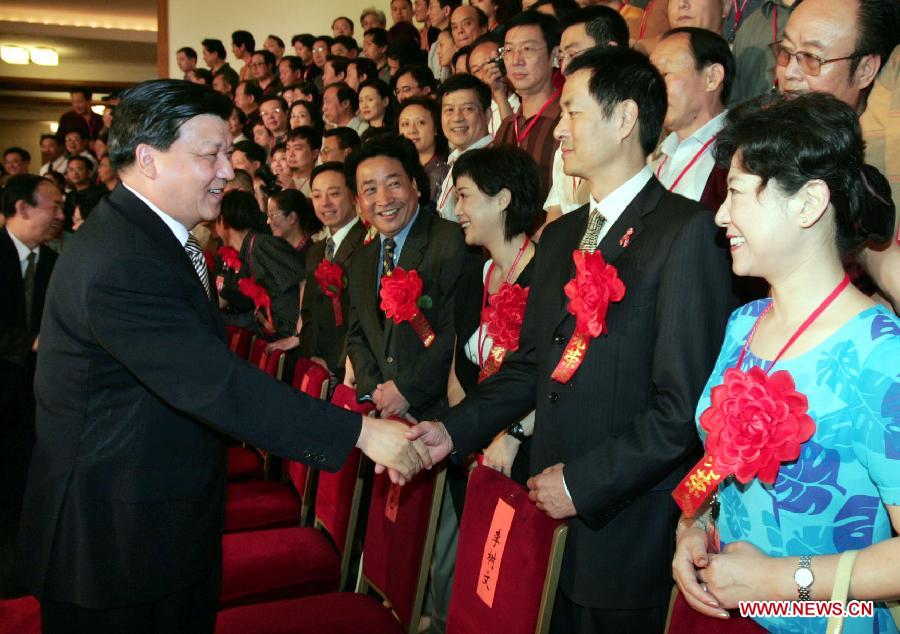 Photo d'archive prise le 19 juillet 2004 montrant Liu Yunshan (à gauche au premier plan), rencontrant les représentants participant à une cérémonie de félicitation pour les artistes et littéraires chinois jeunes et d'age moyen ayant fait preuve de vertu suprême ou de grande réalisation artistique au Grand Palais du Peuple à Beijing, en Chine. (Photo : Li Xueren)