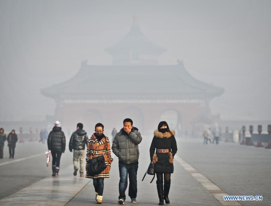 Visiteurs portant des masques au Temple du Ciel enveloppé par le brouillard à Beijing, capitale de la Chine, le 12 janvier 2013. Un épais brouillard a frappé samedi la ville de Beijing. (Xinhua / Li Wen)