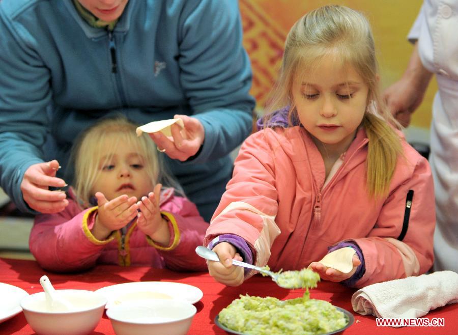 Une étudiante étrangère et ses deux filles apprennent à préparer des raviolis chinois lors des activités organisées pour fêter le Nouvel An chinois à l'Université d'Agriculture de Nanjing, capitale de la province du Jiangsu en Chine. (Xinhua)