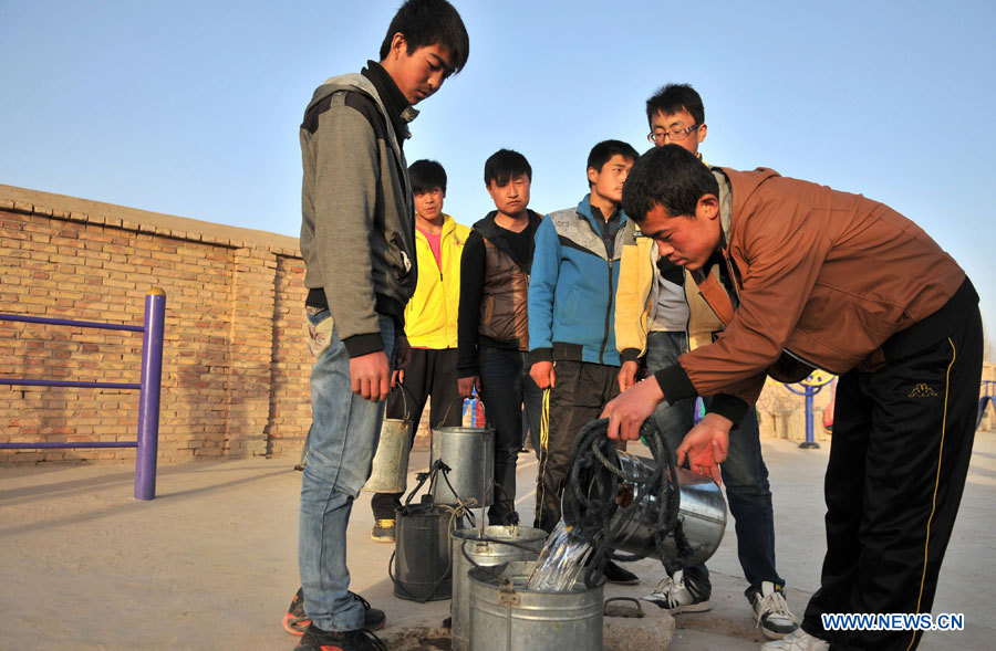 Des élèves de l'Ecole secondaire du district de Shixiawan font la queue pour se procurer de l'eau dans la ville de Dingxi, dans la province chinoise du Gansu (nord-ouest), le 28 mars 2013. Au total, 650.000 habitants manquent d'eau potable dans la province du Gansu en raison de la sécheresse. (Photo : Chen Bin)