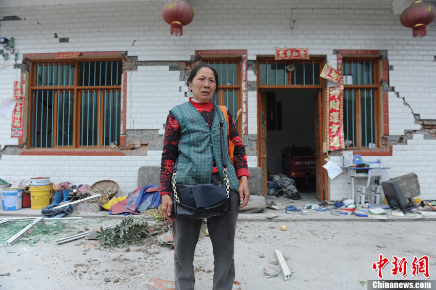 Une habitante du bourg Longmen est en larmes devant sa maison dévastée dans un séisme de magnitude 7,0 survenu dans le district de Lushan de la ville de Ya'an, dans la province du Sichuan, le 20 avril 2013. 