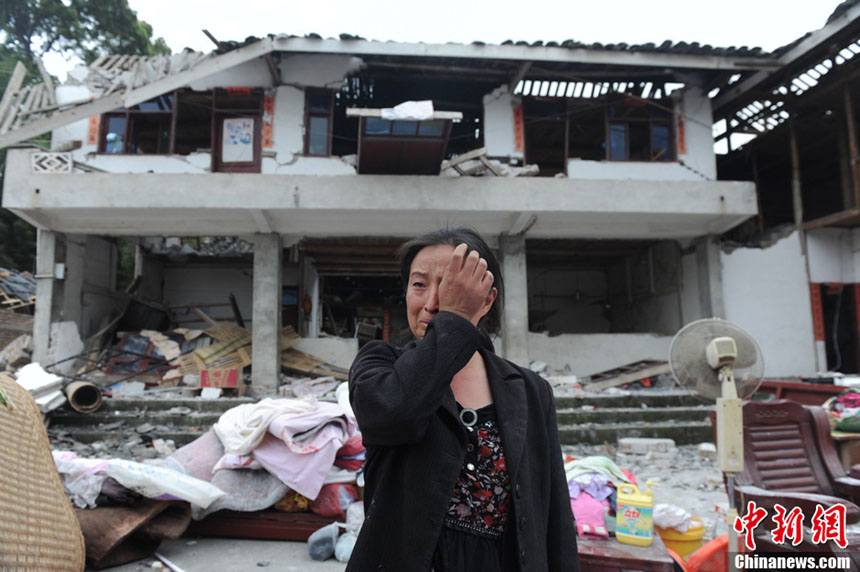 Une habitante du bourg Longmen est en larmes devant sa maison dévastée dans un séisme de magnitude 7,0 survenu dans le district de Lushan de la ville de Ya'an, dans la province du Sichuan, le 20 avril 2013. 