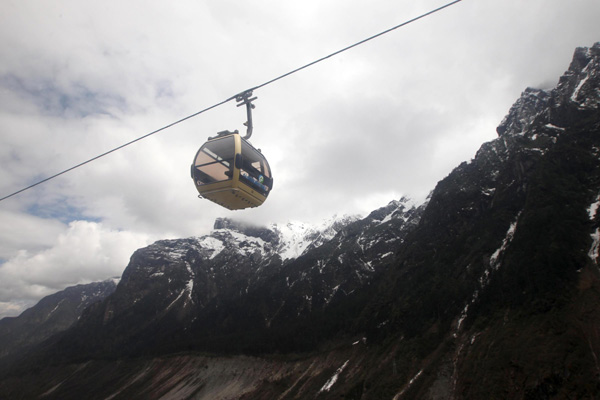 Un téléphérique vide traverse le site touristique de Hailuogou, dans la Province du Sichuan, le 26 avril. Les sites les plus populaires de la province, comme Jiuzhaigou, le Mont Emei, le Mont Qingcheng, Dujiangyan et Hailuogou, ont été partiellement épargnés par le séisme qui a touché Lushan le 20 avril, tuant près de 200 personnes, mais le nombre de touristes sur ces sites a sensiblement diminué. Beaucoup de ces sites touristiques ont réduit les prix des billets pour attirer les visiteurs. [Photo / Xinhua]