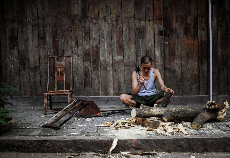 Un homme fend du bois de chauffage dans une rue d'Anren, une ville ancienne du Comté de Dayi, à Chengdu, capitale de la Province du Sichuan, dans le Sud-ouest de la Chine, le 23 mai 2013.