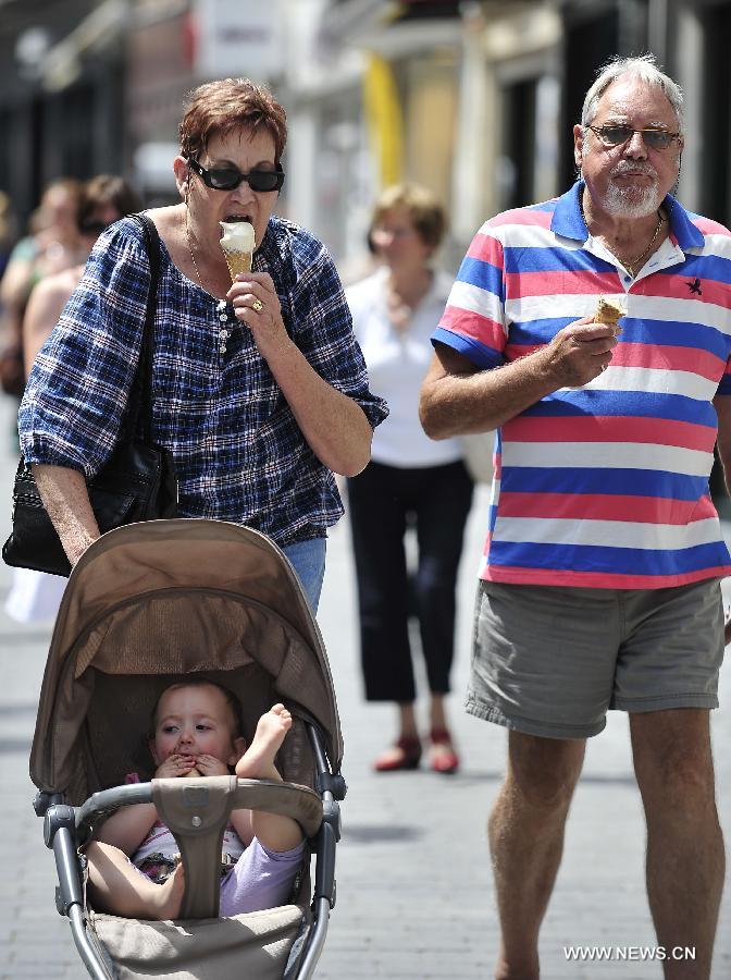 Les gens profitent du soleil d'après-midi au centre-ville de Louvain, en Belgique, le 18 juin 2013. La température a atteint 31°C, la plus haute depuis cette année, suivi d'un hiver et printemps aussi froid et humide. (Xinhua/Ye Pingfan)