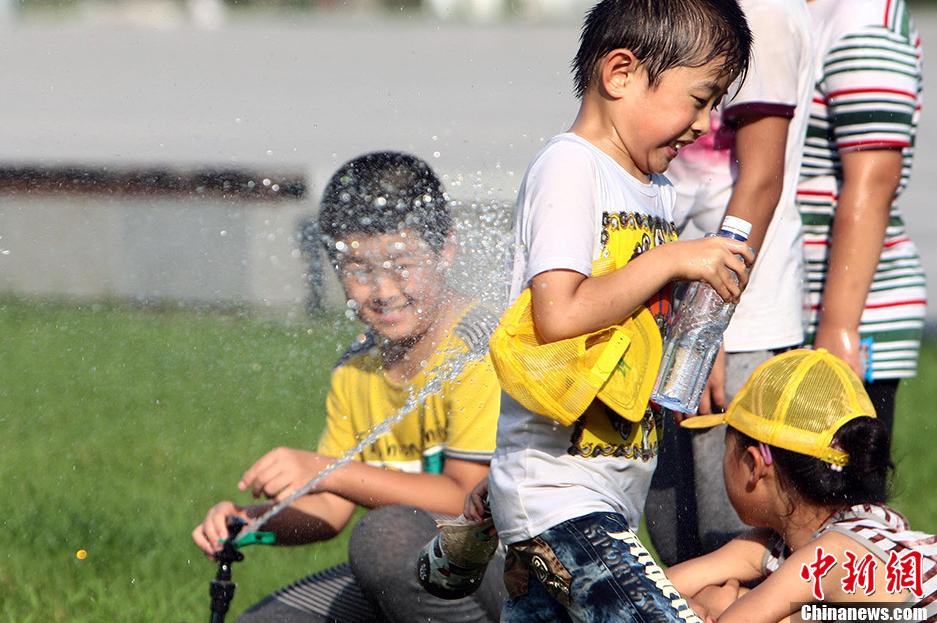 Le 4 ao?t vers le soir, à Taiyuan, dans le Shanxi, des enfants s'amusent avec de l'eau.