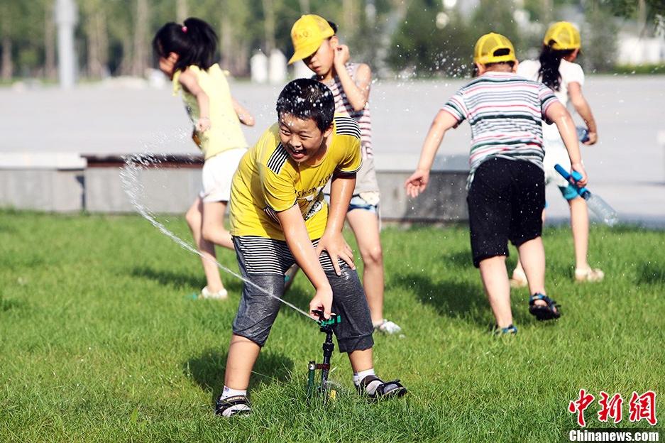 Le 4 ao?t vers le soir, à Taiyuan, dans le Shanxi, des enfants s'amusent avec de l'eau.