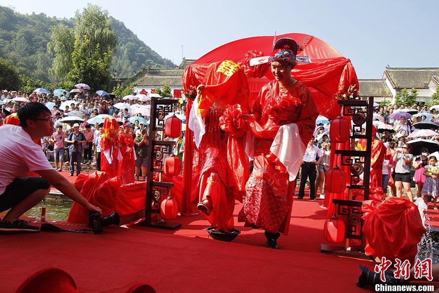 Une des coutumes du mariage traditionnel chinois : la jeune mariée enjambe un brasero, un geste signifiant une rupture totale avec les mauvais esprits du passé. (Photo : Wang Zhongju)