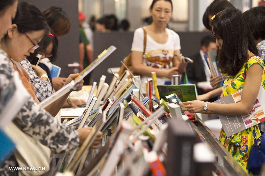 Mercredi 28 ao?t, lors de la 20e Foire internationale du livre de Beijing, des visiteurs lisent les publications exposées. (Photo : Xinhua / Zhaobing)