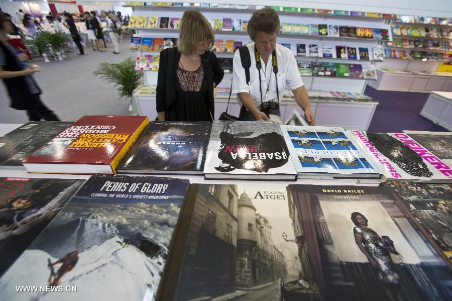 Mercredi 28 ao?t, lors de la 20e Foire internationale du livre de Beijing, des visiteurs lisent les publications exposées. (Photo : Xinhua / Zhaobing)