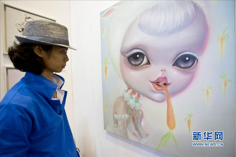 Jeudi 29 ao?t, une visiteuse contemple un tableau présenté lors de la 16e Exposition internationale d'Art de Beijing. (Photo : Xinhua)