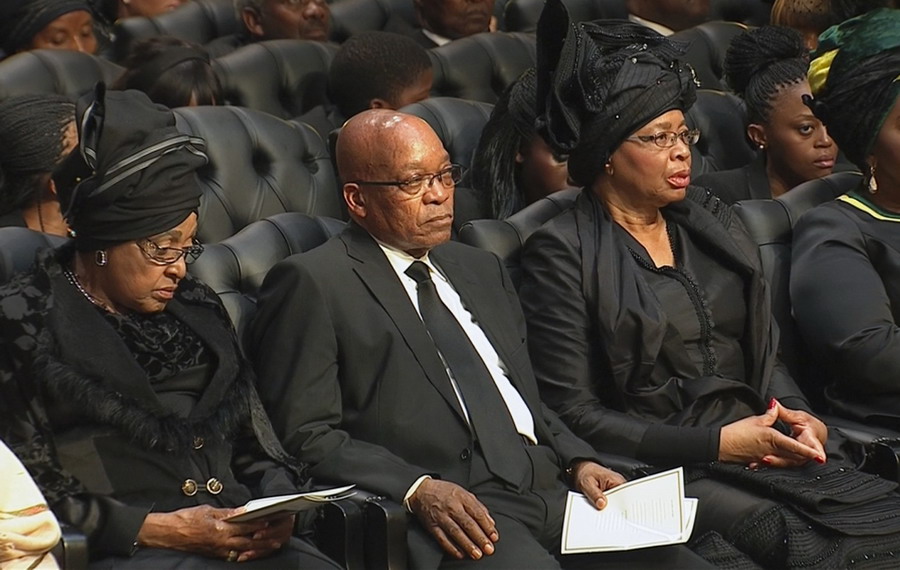 Winnie Mandela, ex-épouse de l'ancien président sud-africain Nelson Mandela, le président sud-africain actuel, Jacob Zuma et Graca Machel, la veuve de Mandela, lors des funérailles de Nelson Mandela dans son village ancestral de Qunu dans la province du Cap oriental, à 900 km au sud de Johannesburg, sur cette photo prise dans une vidéo le 15 décembre 2013 avec la permission de la South Africa Broadcasting Corporation (SABC). 