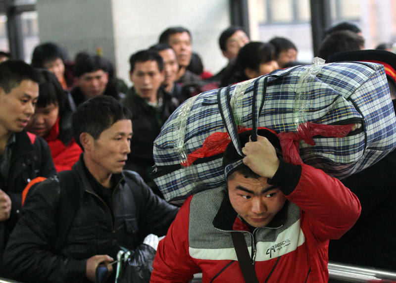 Des passagers attendent pour embarquer à bord d'un train à la gare de l'Ouest de Beijing mardi avant le pic annuel des voyages de la Fête du Printemps de 40 jours, qui commence jeudi. [Photo Zou Hong / China Daily]