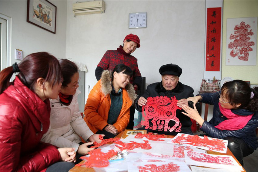 Yu Yongsheng, un ma?tre du papier découpé du Comté de Lüxian, dans la ville de Rizhao, dans la Province du Shandong dans l'Est de la Chine montre ses ?uvres chez lui, le 13 janvier 2014. [photo / icpress.cn]