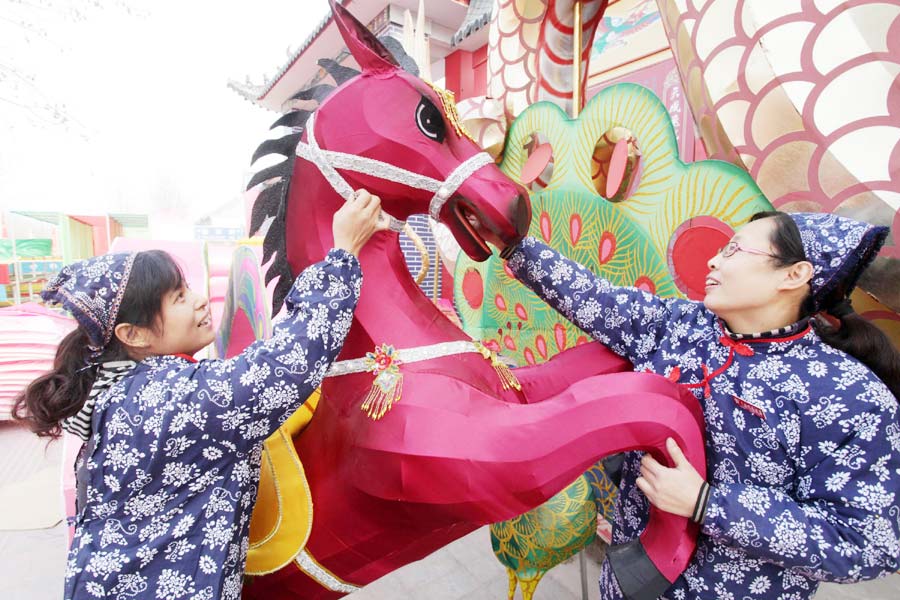 Des artistes populaires finissent leur lanterne sur le thème du cheval à Weifang, dans la province du Shandong.