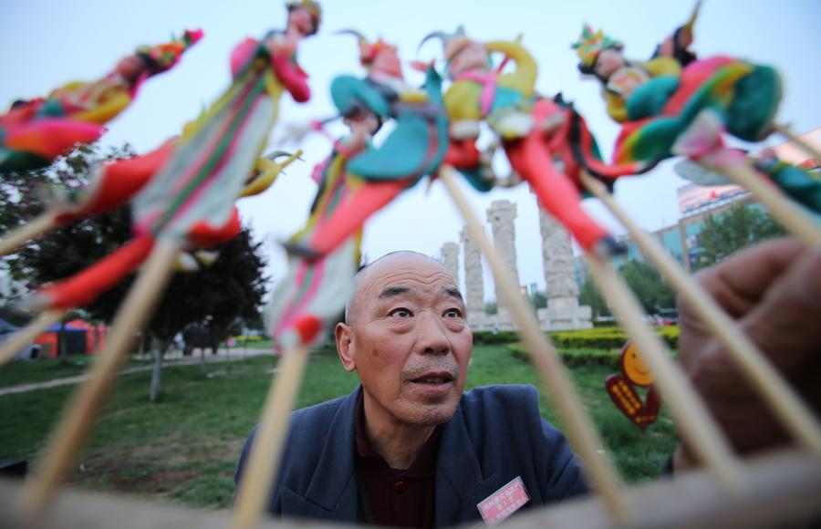 Dong Jinlong vend ses figurines en pate dans la rue, le 21 avril 2014. [Photo/Xinhua]